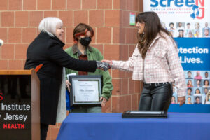 Dr. Kinney presents two of the design contest winners with their certificates.